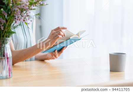 Middle woman reading a book in the living room 94411705
