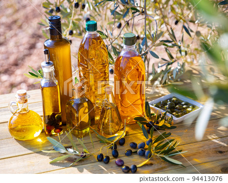Olive oil on wooden table on background of olive tree 94413076