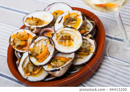 Baked in oven with sauce open seashell served at white plate 94413200