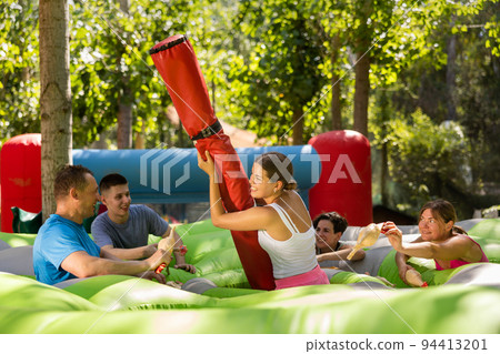 Men and women playing interesting game in adventure park 94413201