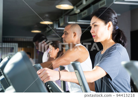 People having running elliptical trainer class in club People having running elliptical trainer class in club 94413218