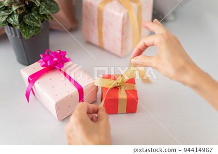 Image of a woman opening a present 94414987