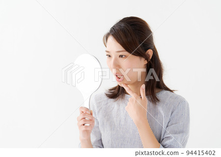 A woman in her twenties doing a dental check A woman in her twenties doing a dental check 94415402