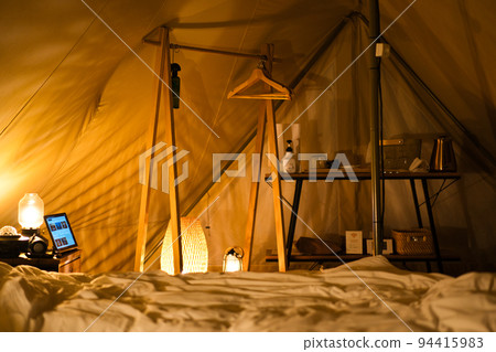 Feel the relaxing night time at the campsite with the light inside the tent 94415983