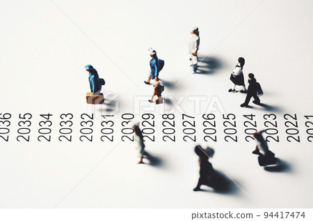 Miniature people walking beside chronology 94417474