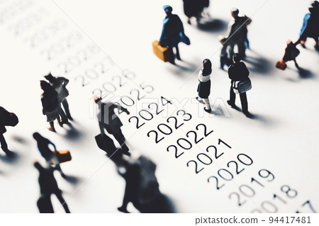 Miniature people walking beside chronology 94417481