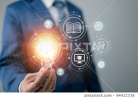 E-learning concept with a person holding a light bulb E-learning concept with a person holding a light bulb 94422336