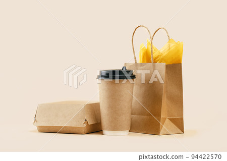 Takeaway paper coffee cup with lunch bag on beige 94422570