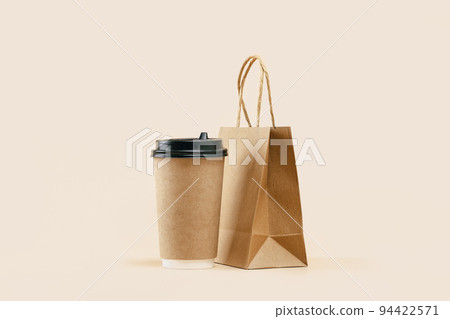 Takeaway paper coffee cup with lunch bag on beige 94422571