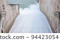 Flowing water through the water gate of the dam. Long exposure. 94423054