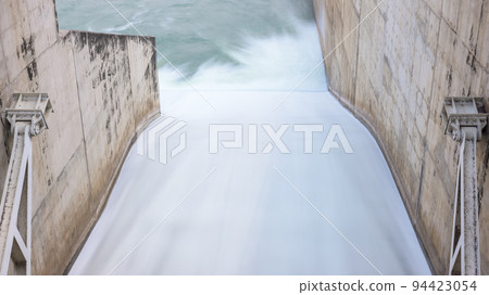 Flowing water through the water gate of the dam. Long exposure. 94423054