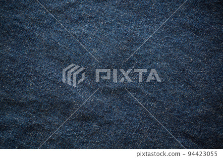 Closeup top view of blue wrinkled jean as a background. Cool tone. Closeup top view of blue wrinkled jean as a background. Cool tone. 94423055