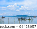 Beautiful view of Songkhla lake that is located in the southern of Thailand with a few of hut as foreground and mountains, blue sky and white cloud as background. Cool tone. Analogous color. 94423057