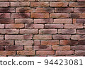 Close up view of old wall that is made from many bricks in pattern. Warm tone. 94423081