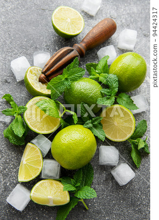 Lime, mint and ice on a dark background. 94424317