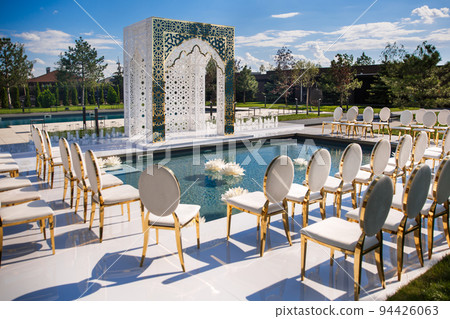 Outdoor wedding ceremony in the garden near the pool Outdoor wedding ceremony in the garden near the pool 94426063