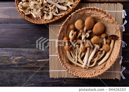 Fresh yanagi matsutake mushroom in basket on wooden background, Table top view 94426283