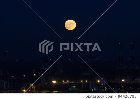 Full moon floating above the city 94426795
