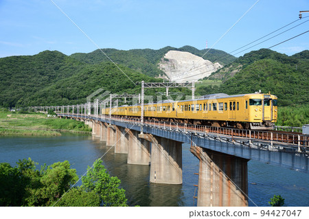 Sanyo Line 115 series local train crossing the Yoshii River Bridge 94427047