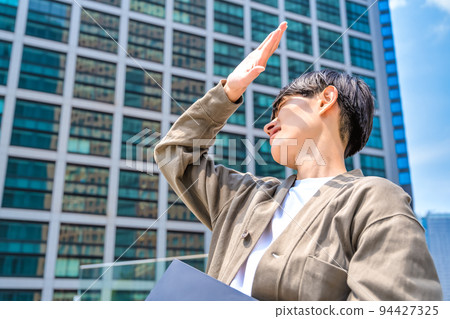 一位身著辦公室休閒裝、拿著筆記本電腦的年輕商人令人眼花繚亂 94427325
