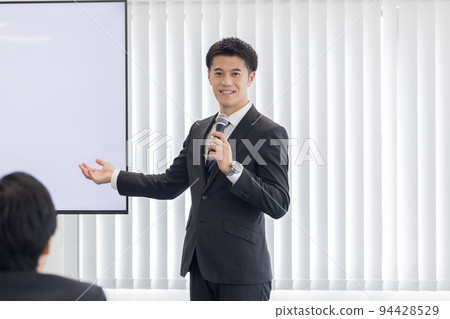Seminar speaker A man holding a microphone and speaking 94428529