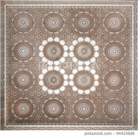 Ancient carved floral ornament in the Moroccan style. Square bas-relief with decorative element in arabic style Ancient carved floral ornament in the Moroccan style. Square bas-relief with decorative element in arabic style 94428886
