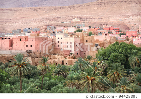 Aerial view of medieval town in Atlas mountains, Morocco, North Africa. Aerial view of old adobe houses and palms 94428893