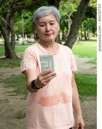 Enjoyable music played by an Asian woman with a smile on the ground. 94430754