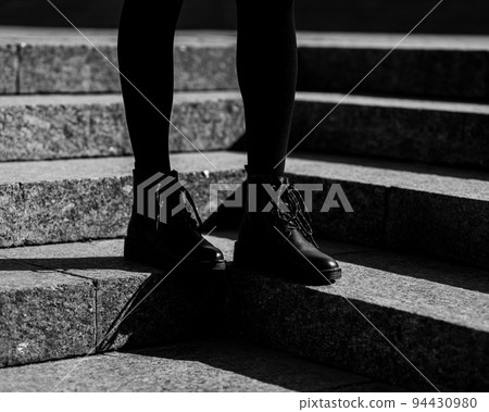 Woman legs in black ankle boots 94430980