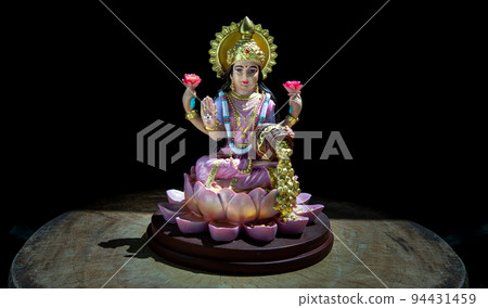 Hindu cosmos Maha laxshmi statue decorated with Flower Garland. Statue of Goddess of Wealth. 94431459