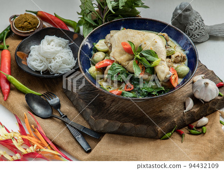 Green curry with Chicken and Thai eggplants (Kaeng khiao wan) in Ceramic bowl served with Rice noodles. 94432109