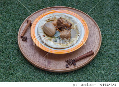 Green curry with Stewed pork leg, Boiled egg and Tofu on Homemade pita bread. 94432123