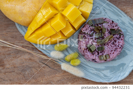 Close-up of Fresh ripe yellow mango fruit (Barracuda mango) and Riceberry topping pandan leaf. Close-up of Fresh ripe yellow mango fruit (Barracuda mango) and Riceberry topping pandan leaf. 94432231