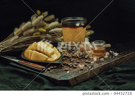 Glass of Iced tropical Mango smoothie mixed Espresso coffee served with Honey on the Wooden cutting board. 94432728