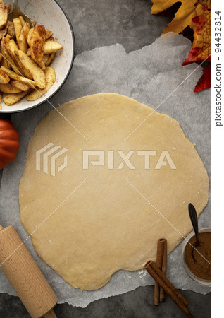Apple pie. Cooking autumn strudel with fresh apples and cinnamon. Dark background. 94432814