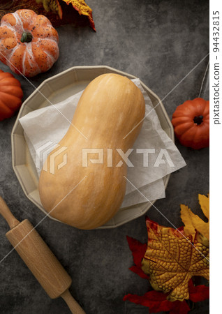 Autumn baking concept with butternut squash with rolling pin and baking pan. Top view. 94432815