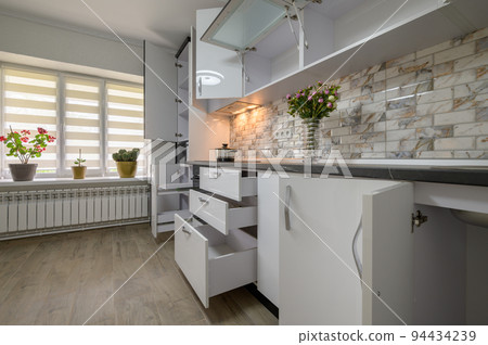 Renovated Interior for modern trendy white kitchen with doors open 94434239