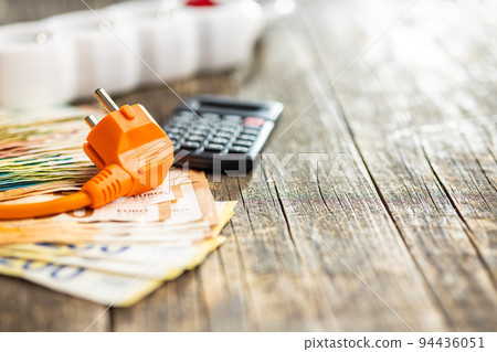 Electric plug, calculator and euro money on wooden table. Concept of increasing electric prices. Electric plug, calculator and euro money on wooden table. Concept of increasing electric prices. 94436051