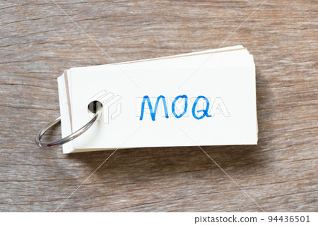 Flash card with handwriting in word MOQ (Abbreviation of Minimum Order Quantity) on wood background 94436501