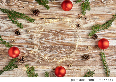 Christmas composition with fir tree branches and lighting garland on wooden background. Christmas frame, flat lay. Xmas greeting banner with copy space Christmas composition with fir tree branches and lighting garland on wooden background. Christmas frame, flat lay. Xmas greeting banner with copy space 94436735