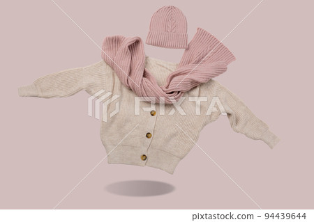 Beige sweater with buttons, pink scarf and hat, as if levitating, casting a shadow, concept 94439644