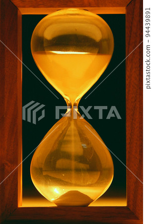 Sand falls inside hour glass  94439891
