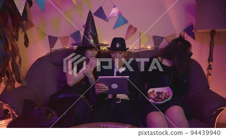A group of friends is watching a creepy Halloween movie on a tablet. Fright 94439940