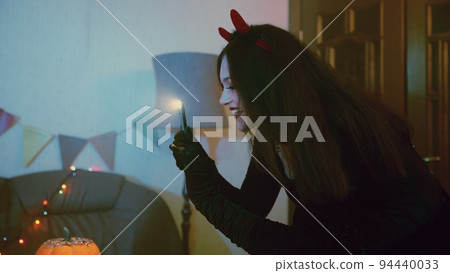 A girl takes pictures or takes pictures on her friends' phone for Halloween 94440033