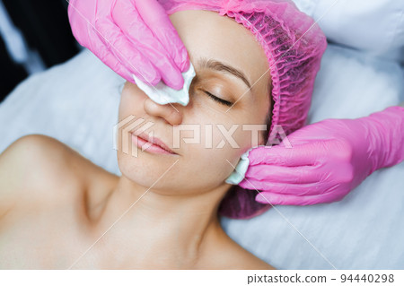 Cosmetologist applies cream on the skin of the client Cosmetologist applies cream on the skin of the client 94440298