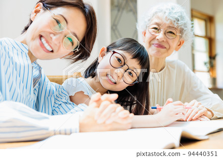 A family watching over an elementary school girl studying A family watching over an elementary school girl studying 94440351