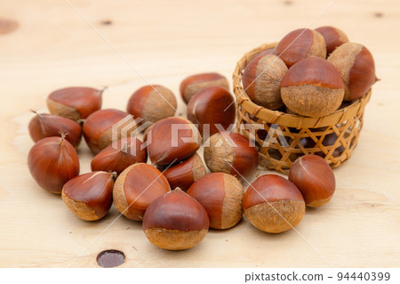 A lot of chestnuts Chestnuts overflowing from a strainer A lot of chestnuts Chestnuts overflowing from a strainer 94440399
