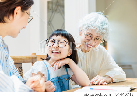 A family watching over an elementary school girl studying A family watching over an elementary school girl studying 94440715