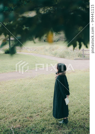 woman standing under a tree 94441115