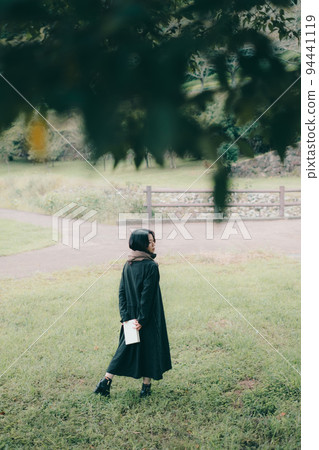 woman standing under a tree 94441119